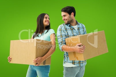 Composite image of happy young couple with moving boxes