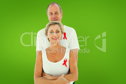 Composite image of mature couple supporting aids awareness toget