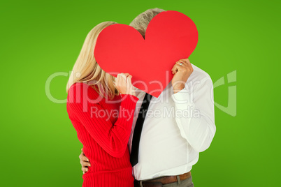 Composite image of handsome man getting a heart card form wife