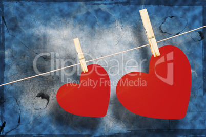 Composite image of hearts hanging on a line