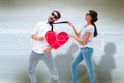 Composite image of brunette pulling her boyfriend by the tie