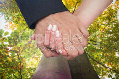 Composite image of newlyweds holding hands close up