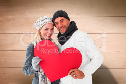 Composite image of smiling couple in winter fashion posing with