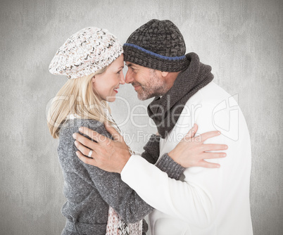 Composite image of happy couple in winter fashion embracing