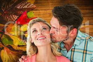 Composite image of handsome man kissing girlfriend on cheek