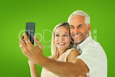 Composite image of happy couple posing for a selfie