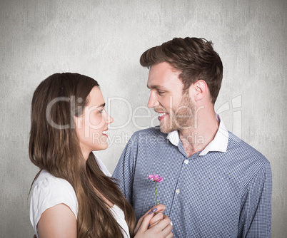 Composite image of man kissing woman as she holds flower