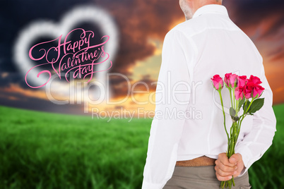 Composite image of man holding bouquet of roses behind back