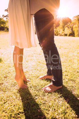 Couples bare feet standing on grass