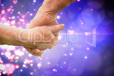 Composite image of elderly couple holding hands