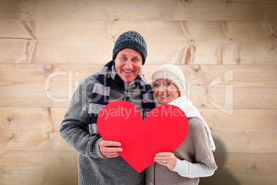 Composite image of happy mature couple in winter clothes holding