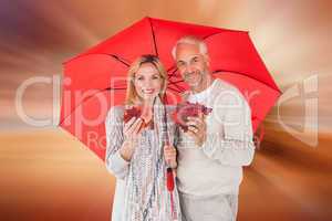 Composite image of smiling couple showing autumn leaves under um