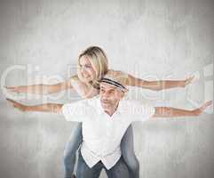 Composite image of happy man giving his partner a piggy back