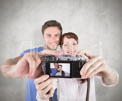 Composite image of couple using camera for picture