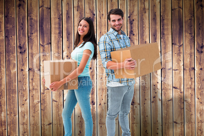 Composite image of happy young couple with moving boxes