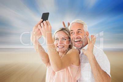 Composite image of happy couple posing for a selfie