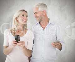 Composite image of happy couple texting on their smartphones