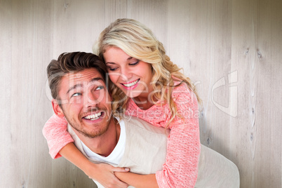 Composite image of handsome man giving piggy back to his girlfri