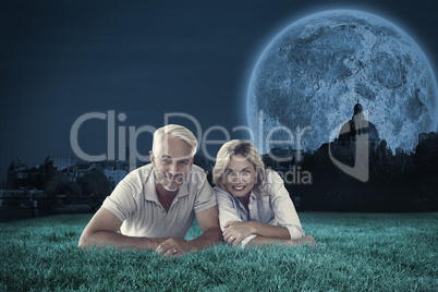 Composite image of happy couple lying smiling at camera