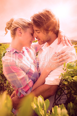 Smiling couple embracing outside among the bushes