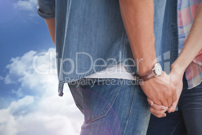 Composite image of hip young couple holding hands