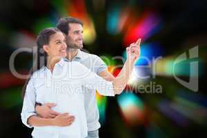 Composite image of cute couple embracing and pointing