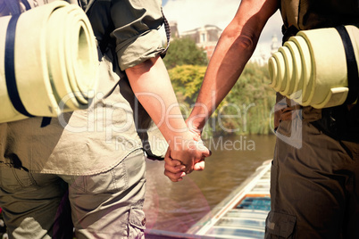 Composite image of hitch hiking couple standing holding hands on