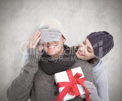 Composite image of woman surprising husband with gift