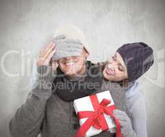 Composite image of woman surprising husband with gift