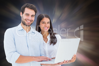 Composite image of attractive young couple holding their laptop