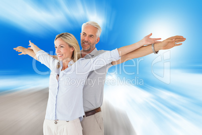 Composite image of happy couple standing with arms outstretched