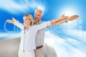 Composite image of happy couple standing with arms outstretched