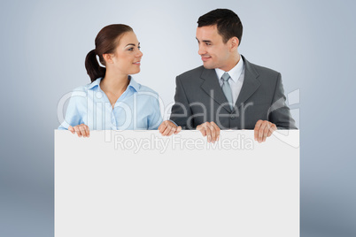 Composite image of business partners looking at each other while