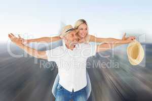 Composite image of happy man giving his partner a piggy back