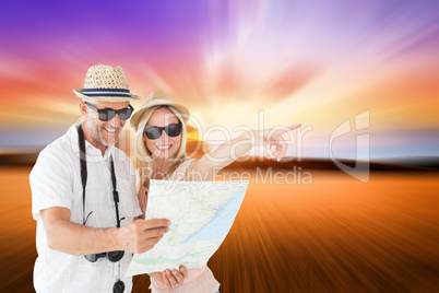 Composite image of happy tourist couple using map and pointing