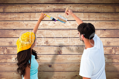 Composite image of happy young couple painting together