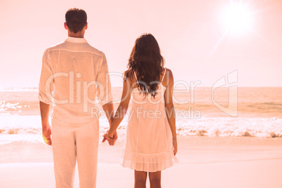 Attractive couple holding hands and watching the ocean