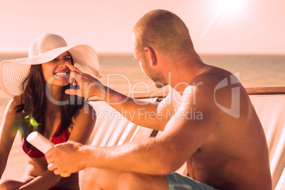 Handsome man applying sun cream on his girlfriends nose