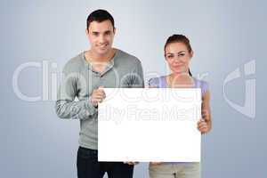 Composite image of young couple holding banner together