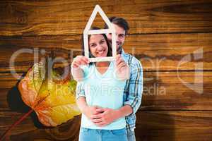 Composite image of happy young couple with house shape
