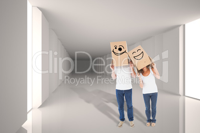 Composite image of mature couple wearing boxes over their heads