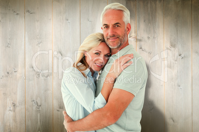 Composite image of happy couple standing and smiling at camera