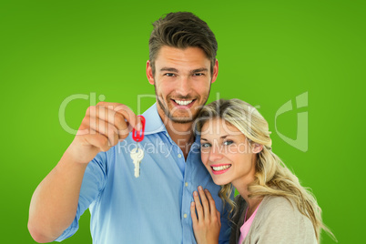 Composite image of attractive young couple showing new house key