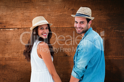 Composite image of happy hipster couple holding hands and smilin