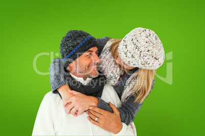 Composite image of happy couple in winter fashion embracing