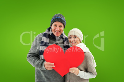 Composite image of happy mature couple in winter clothes holding