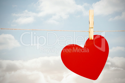 Composite image of heart hanging on line