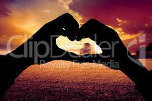 Composite image of woman making heart shape with hands