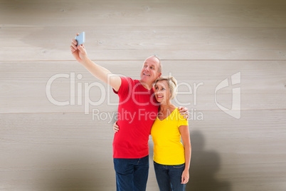 Composite image of happy mature couple taking a selfie together