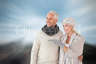 Composite image of happy couple in winter fashion looking